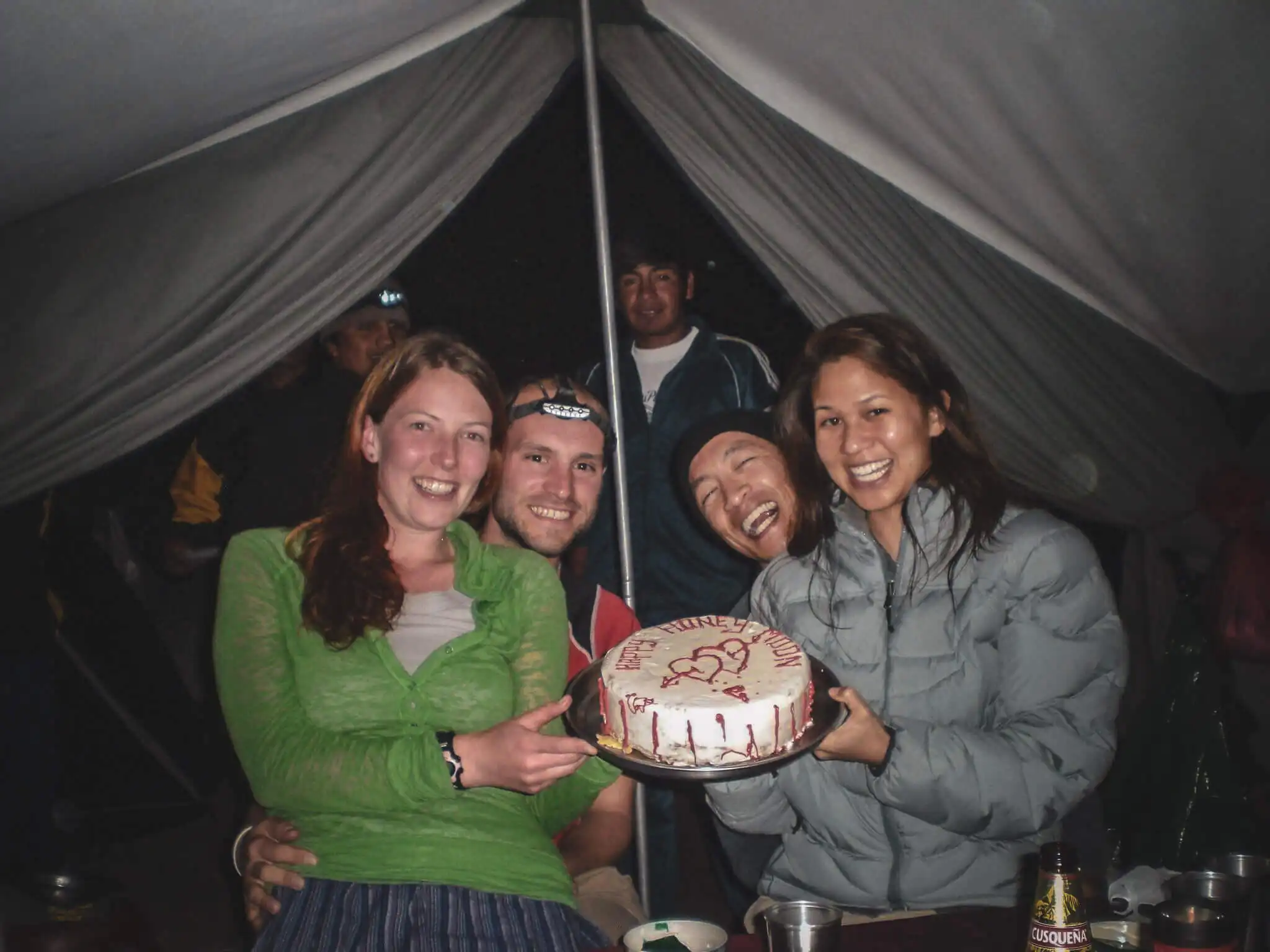 Travelers and cooks presenting a celebration cake inside an Inca Trail dining tent