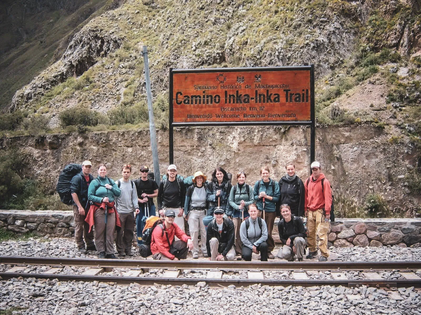 A group of hikers with backpacks at the Km 82 Inca Trail sign